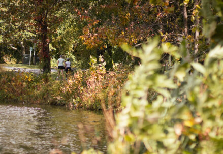 Two people walk down the trail at Lake Artemesia in College Park on Oct. 17, 2023. (Neelay Sachdeva/The Diamondback)