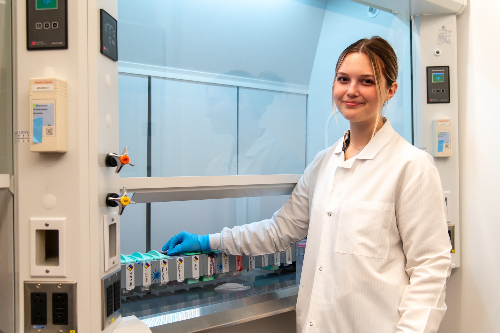 Aubrey Alexander stains slides in preparation for imaging